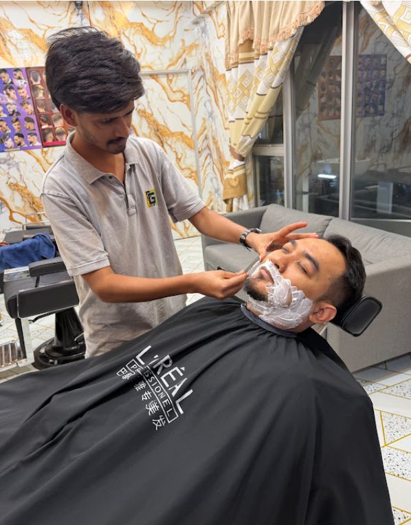 Barber shaving a customer at Newaj Barber Shop Setia Alam